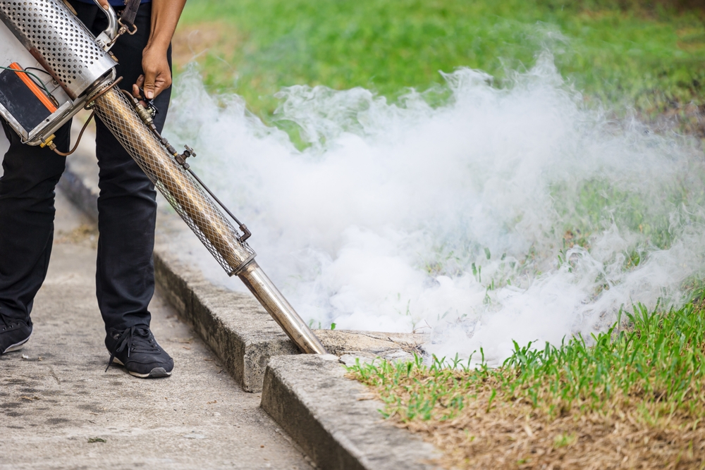 Technician fogging a curbside area for mosquito control